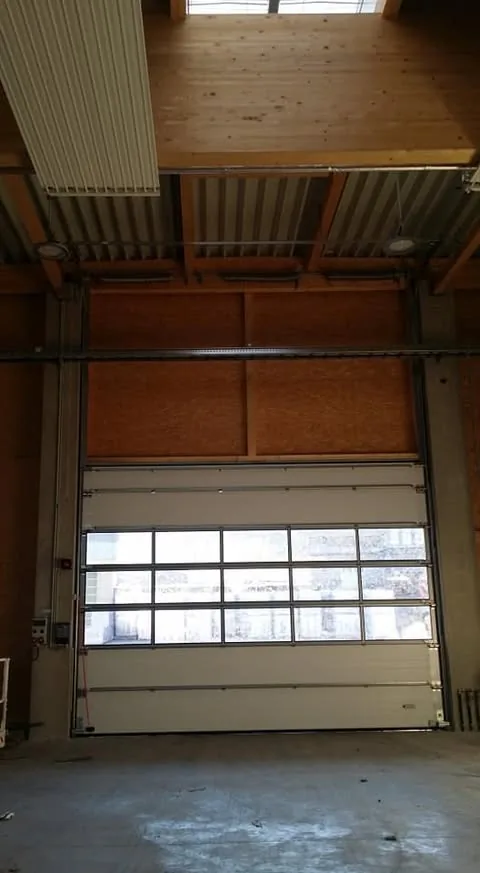 Weißes Industrie-Sektionaltor mit Sichtfenstern in einer Halle